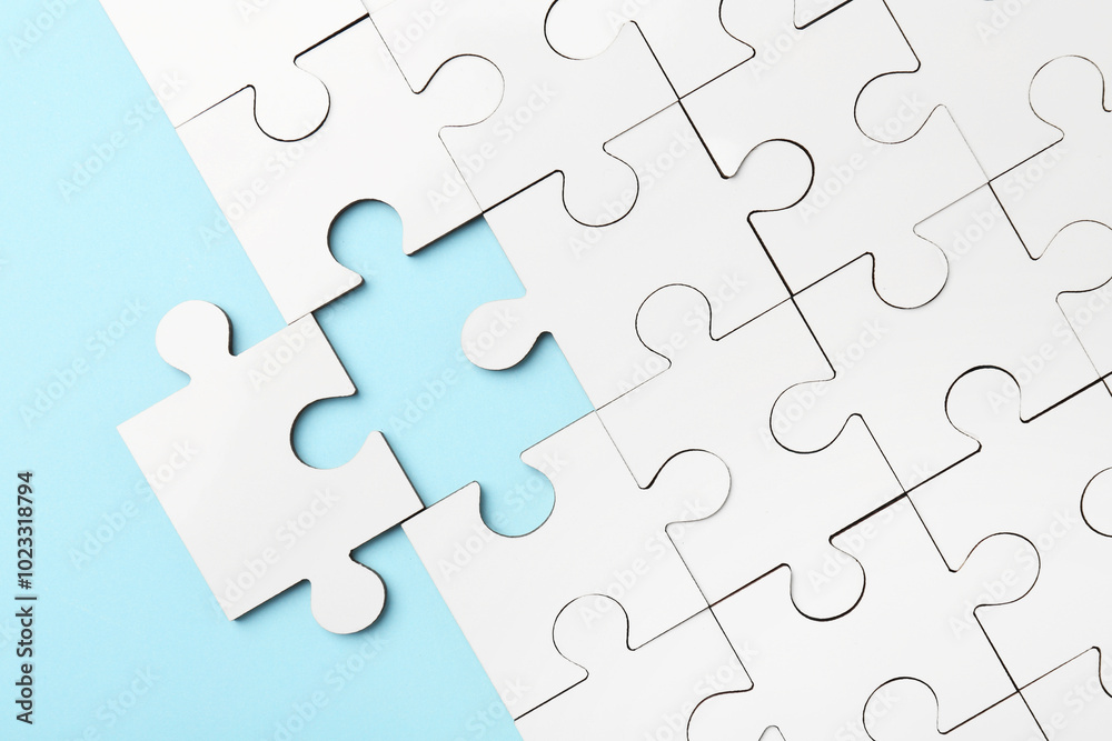 White puzzle pieces on light blue background, top view White puzzle pieces on light blue background, top view