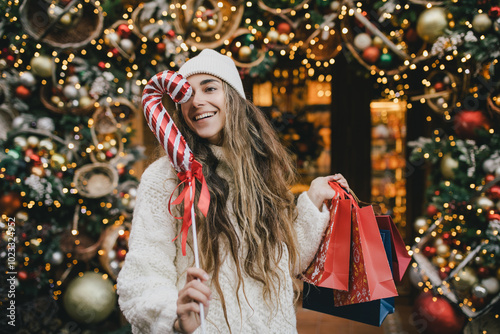 Young beautiful womam enjoying Christmas shopping on a decorated street.