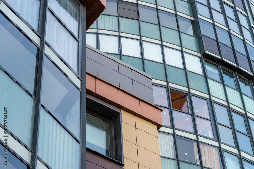 A tall building with many windows. The building has a modern look and he is a commercial or office building A tall building with many windows. The building has a modern look and he is a commercial or office building
