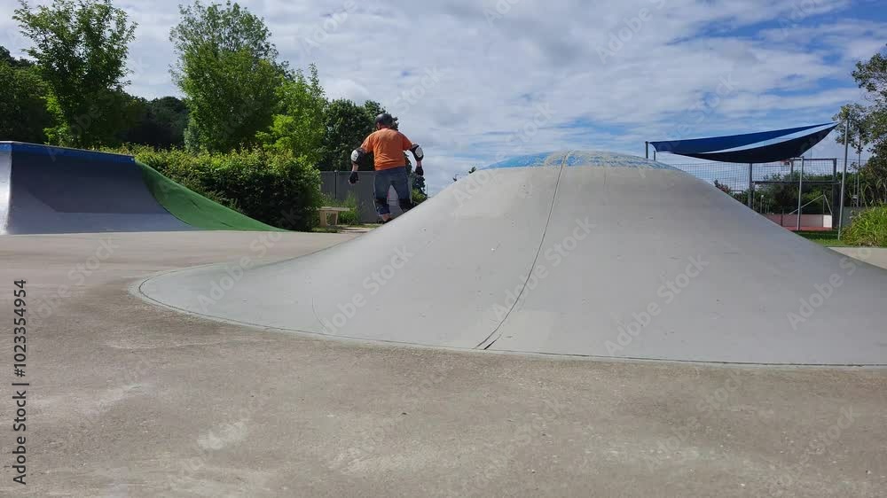Ein Mann, der mit Inlineskates auf einer Halfpipe in einem Skatepark fährt. 