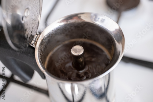 Brewing coffee with moka pot in close-up