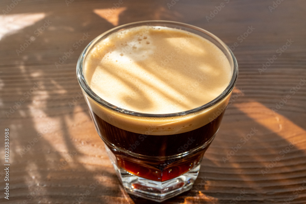 espresso lungo in glass cup on wooden floor espresso lungo in glass cup on wooden floor