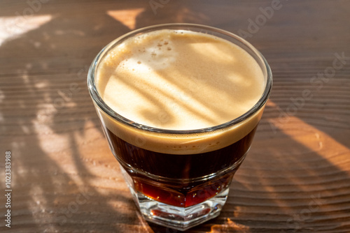 espresso lungo in glass cup on wooden floor