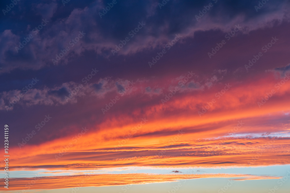 Fototapeta premium Glowing real sky at sunset texture background overlay. Dramatic red and orange clouds.