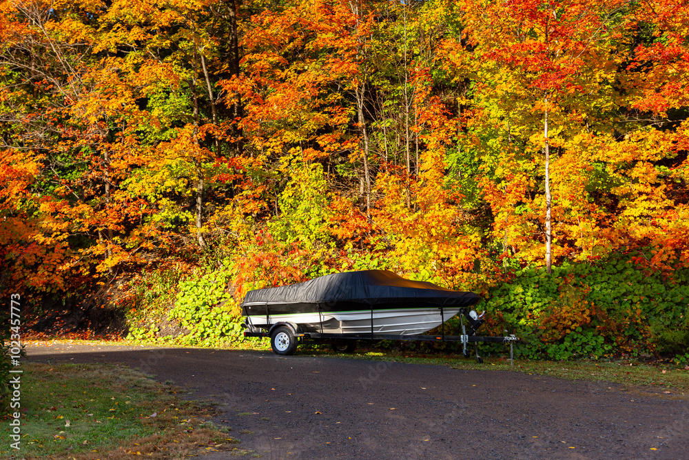 Small covered speedboat parked on trailer in entryway seen during a beautiful fall day in St. François, Island of Orleans, Quebec, Canada
Small covered speedboat parked on trailer in entryway seen during a beautiful fall day in St. François, Island of Orleans, Quebec, Canada