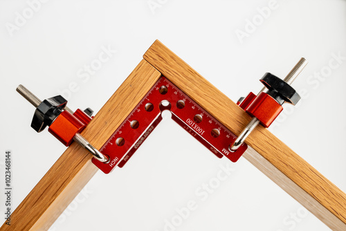 set of red anoodised aluminium woodworking cabinet corner clamps with fixing bolts and knobs to create a right angle