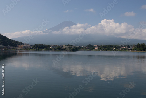 Beautiful image of Mount Fuji shot across Lake Kawaguchi. The water is very reflective. The clouds floating past the mountain makes this look like a magical image. This was taken is Fujiyoshida Japan.