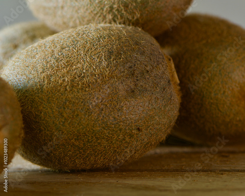 kiwi fruits, cutting board, still life, green flesh, brown skin, seeds, texture, close-up, sliced kiwi, whole kiwi, juicy, tropical fruit, vibrant color, healthy snack, fresh produce, fruit arrangemen photo