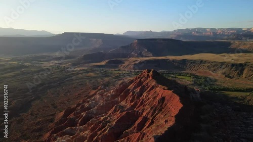 Wallpaper Mural Aerial drone footage over red rock cliffs surrounded by mountains and desert in the background at sunset Torontodigital.ca
