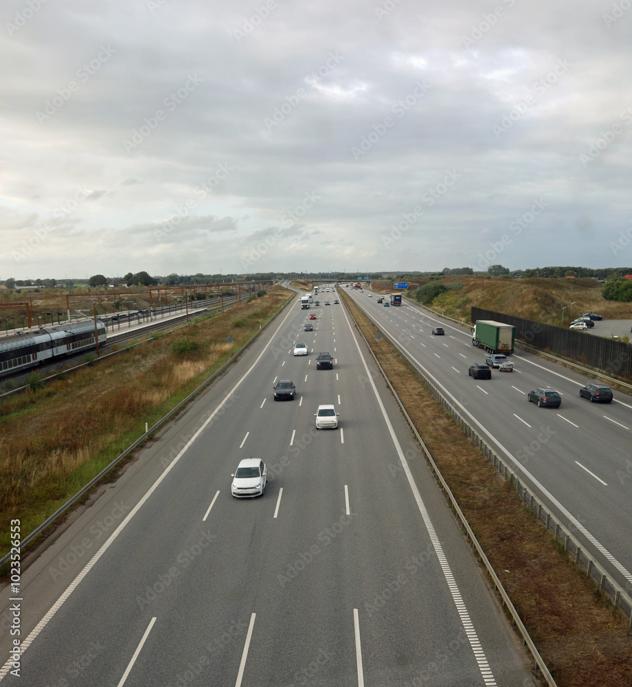 Fototapeta premium very wide four-lane highway with cars and vehicles speeding along the road seen from above