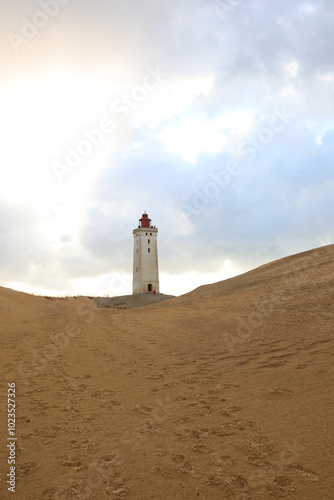 abandoned lighthouse called Rubjerg Knude Fyr surrounded by sandy dunes on the Jutland Peninsula in Northern Denmark photo