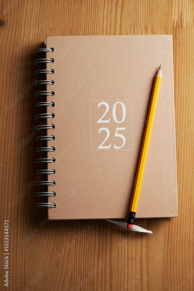 2025 brown diary with pencil on top of wood table 2025 brown diary with pencil on top of wood table