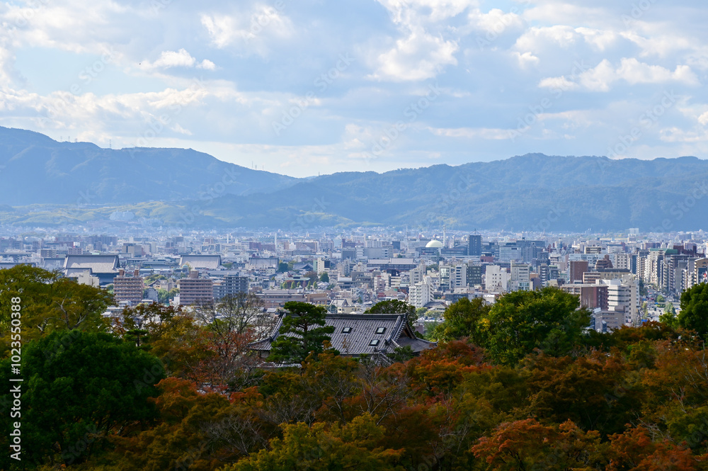 Obraz premium The view of Kyoto city skyline with blue sky and trees from kiyomizu-dera temple in Kyoto, Japan. Major tourist attraction in Kansai region in Japan. Travel concept. Japan cityscape.