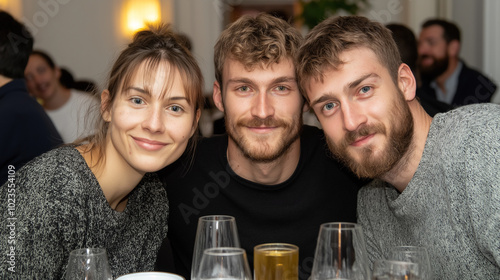 Three friends smiling at a gathering, enjoying drinks and good company, capturing a moment of togetherness and happiness.