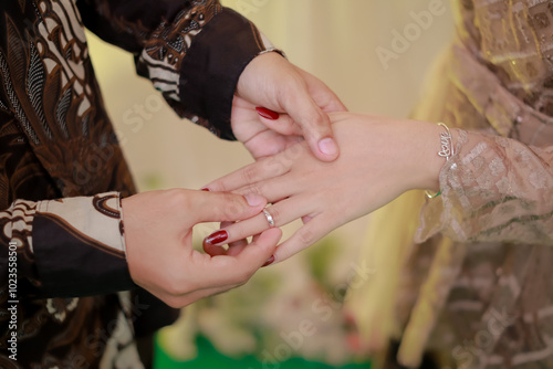 Man holding woman's hand. Man marriage proposal. Boyfriend proposing to his girlfriend to get married. Concept of people relationship, ring present and love. Men's batik shirt