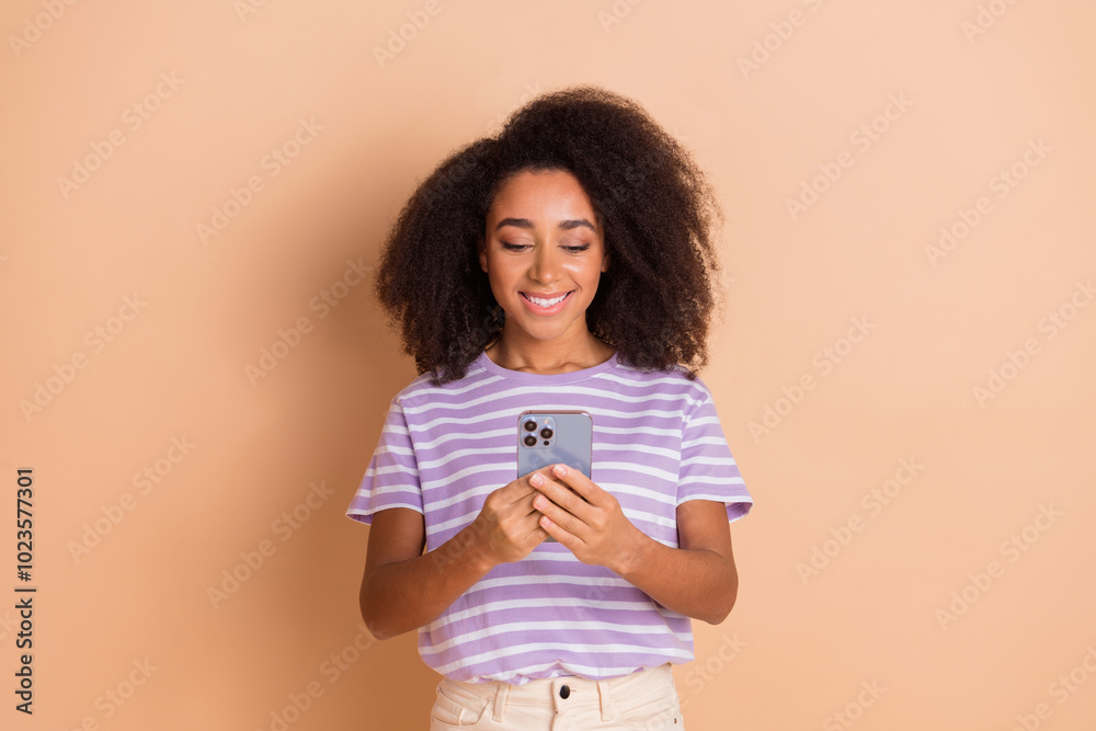 Portrait of pretty young girl use phone wear striped t-shirt isolated on beige color background Portrait of pretty young girl use phone wear striped t-shirt isolated on beige color background