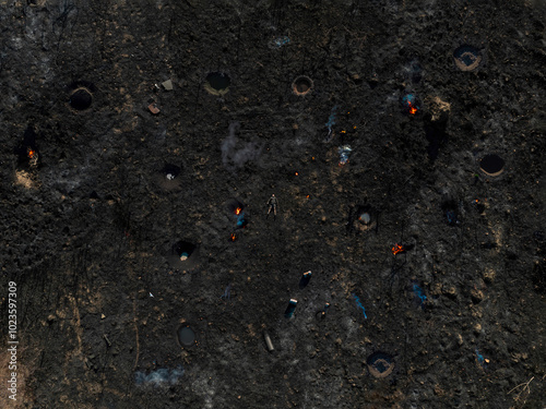 A man in the center of a field completely destroyed by war photo