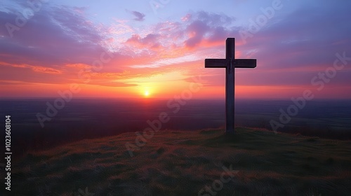 silhouetted cross standing tall on a hill during holy week bathed in soft twilight hues evoking a sense of peace and reflection as the sun sets behind the horizon