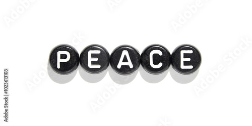 Black round beads with white letters spelling peace on white background for mindfulness and harmony concepts.