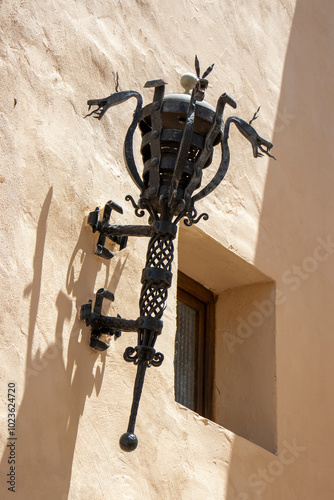 Ornate wrought iron wall lantern on stucco facade