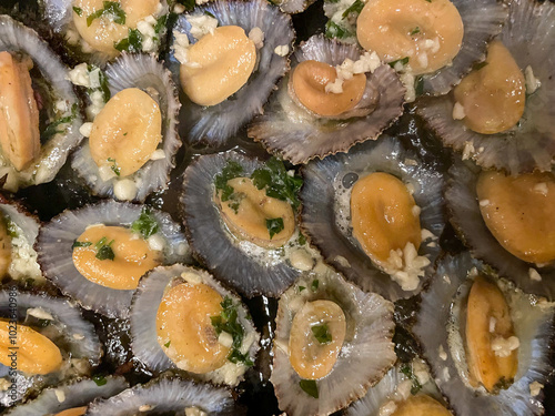 Grilled limpets, a traditional Azorean dish, served with fresh lemon and herbs. A delightful taste of the sea, showcasing the region's rich culinary heritage.