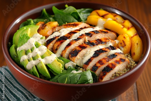 A colorful power bowl filled with grilled chicken, quinoa, spinach, and avocado, drizzled with a light olive oil dressing