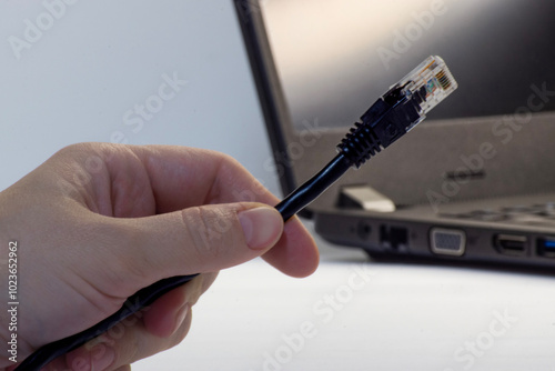 man 's hand connecting laptop computer to internet withethernet lan cable