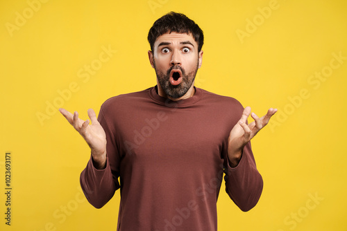 Portrait of excited, shocked bearded man with open mouth looking at camera with open hands