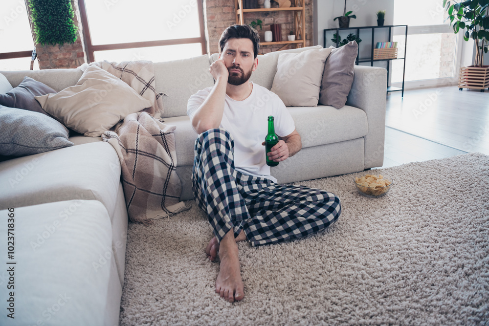 Obraz premium Photo of attractive frustrated man wear pajama sitting on sofa dream think weekend room interior indoors