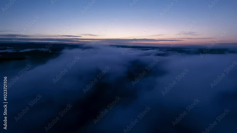 Aerial view of a dark cloudy sky at dawn with subtle light on the horizon