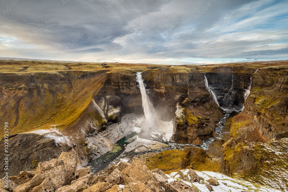 Fototapeta premium Dramatic landscape of Haifoss Waterfall in Landmannalaugar canyon, Iceland. at sunset. Spectacular view in highland wilderness. Winter snow.