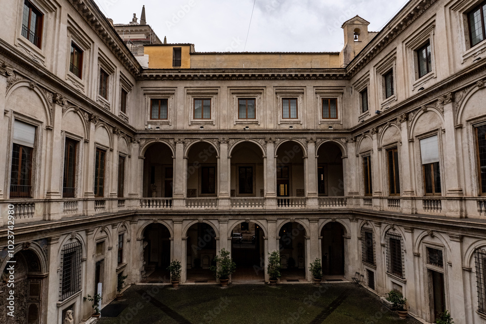 The courtyard of a building is empty and has a lot of windows The courtyard of a building is empty and has a lot of windows