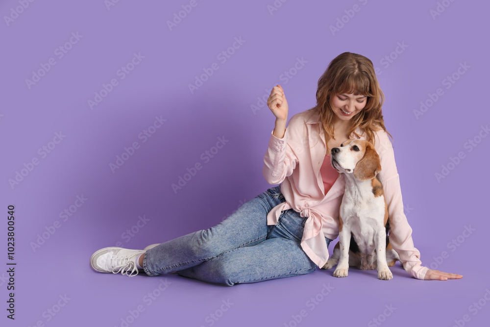 Young woman with cute beagle dog on lilac background Young woman with cute beagle dog on lilac background