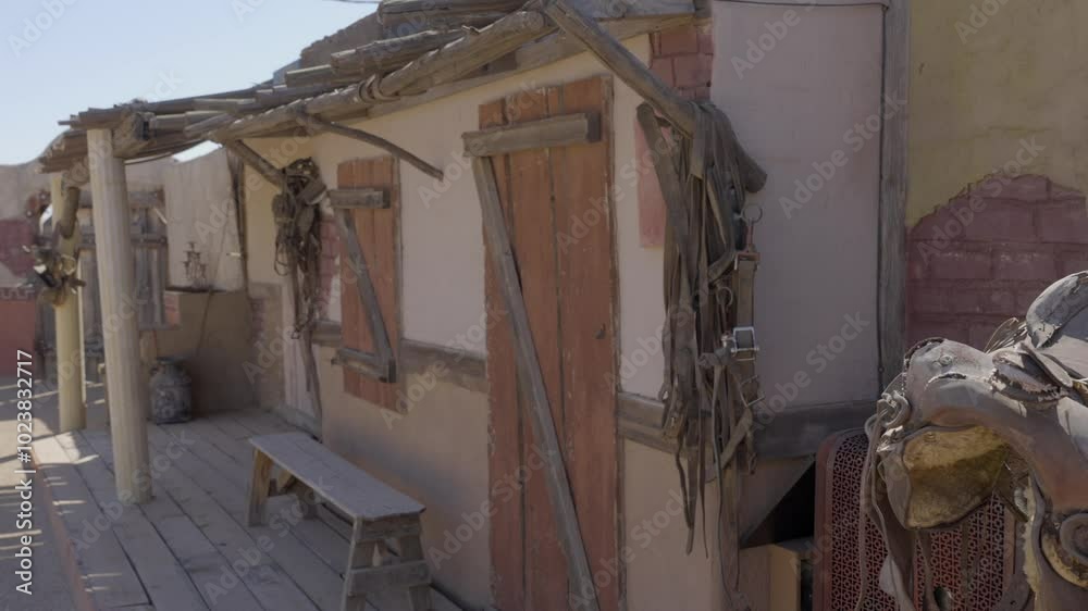 This video shows a saddle hanging on the outside of an old western building. This video shows a saddle hanging on the outside of an old western building.