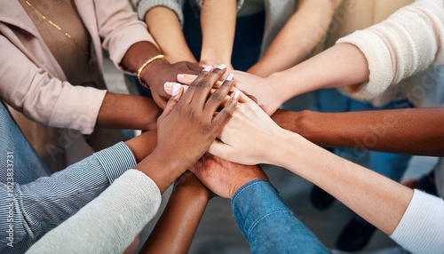 A group of people with their hands in the middle and stacked on top of each other's hands; a team huddle with all hands on deck; teamwork makes the dream work; communication photography