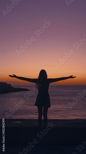 Silhouette of a woman with arms outstretched, standing on a pier at sunset