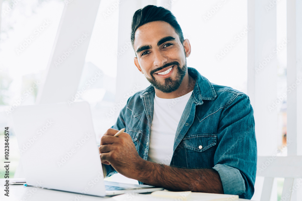 Portrait of cheerful hipster guy with cute smile on face enjoying break from online work with open laptop computer, Spanish male freelancer sitting at street cafeteria with good internet connection Portrait of cheerful hipster guy with cute smile on face enjoying break from online work with open laptop computer, Spanish male freelancer sitting at street cafeteria with good internet connection