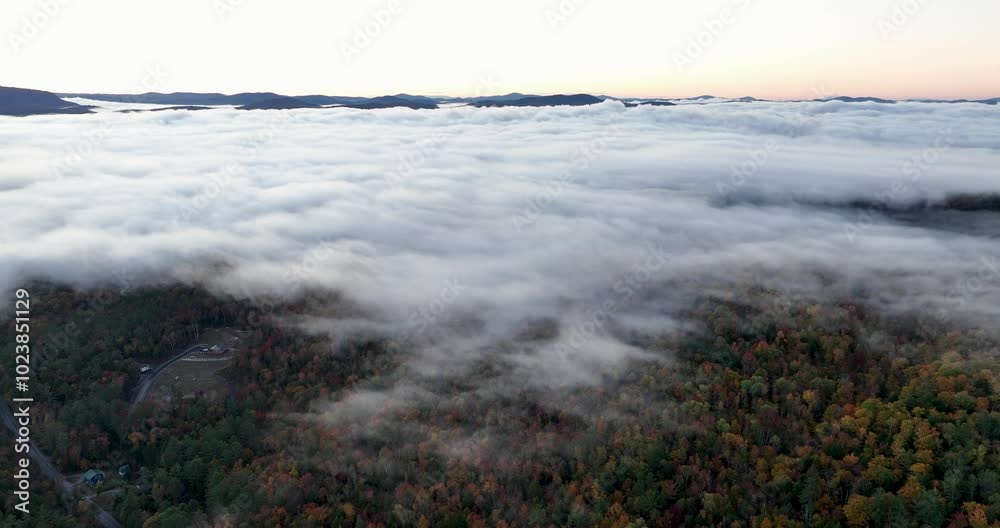 Aerial view of a mountain range covered in vibrant fall foliage, with mist and fog drifting over the colorful forested hills, capturing the beauty of the autumn season. Aerial view of a mountain range covered in vibrant fall foliage, with mist and fog drifting over the colorful forested hills, capturing the beauty of the autumn season.