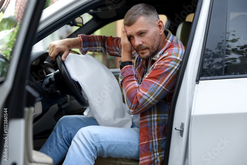 Tableau sur toile Injured man near opened airbag in automobile after car accident
