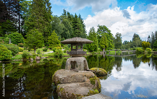 Background photography of garden with pond, stone pagoda and path; public park in Dollar, Scotland, UK, botanic garden; reflection; bushes; flowers, trees