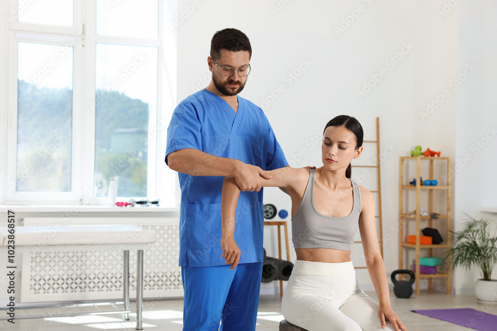 Fototapeta premium Physiotherapist working with patient in rehabilitation center