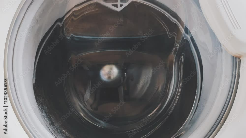 The laundry is spinning in the drum of the washing machine. The laundry is spinning in the drum of the washing machine.
