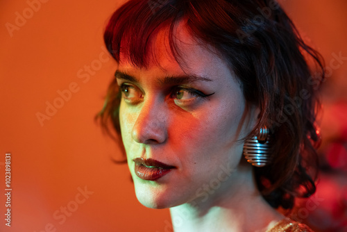 Artistic portrait of a woman with red lighting and striking expression photo