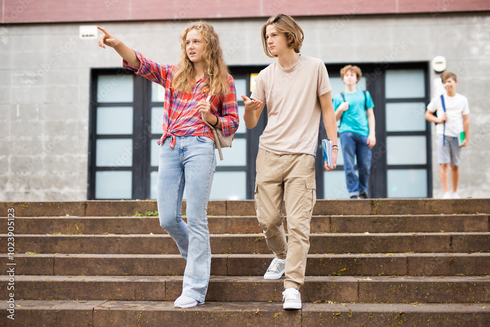 Obraz premium Girl points to the guy with her hand at someone on campus