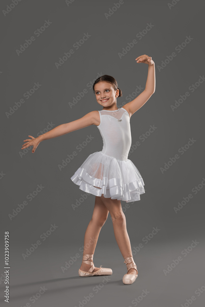 Cute little ballerina dancing on grey background Cute little ballerina dancing on grey background