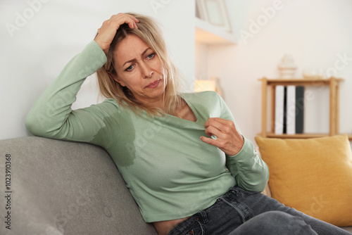 Foto Menopause. Woman suffering from hot flash on sofa at home