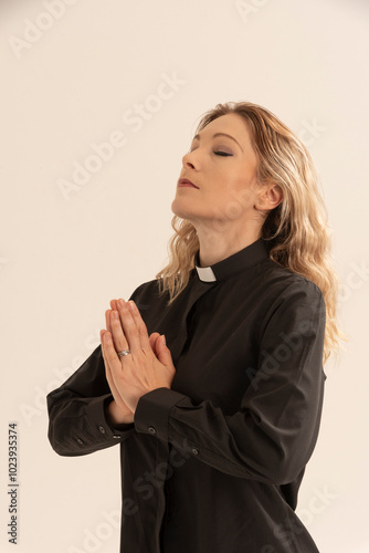 West Sussex England UK. 17.08.2024. Woman priest wearing a clerical collar and hands together in prayer. photo