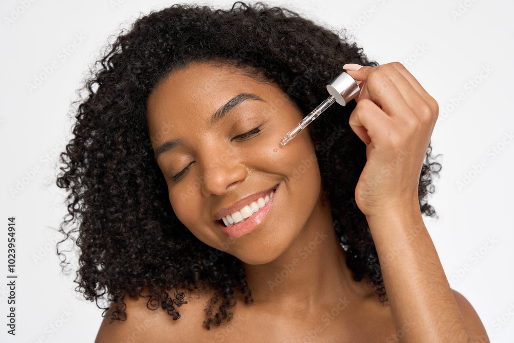 Happy young African woman model applying facial moisturizing serum enjoying healthy glowing face perfect skin care advertising facial beauty treatment cosmetic product isolated on white background. Happy young African woman model applying facial moisturizing serum enjoying healthy glowing face perfect skin care advertising facial beauty treatment cosmetic product isolated on white background.