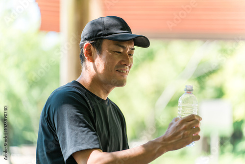 運動中に水・ミネラルウォーターを飲む男性（水分補給・運動・ワークアウト・ランニング・ウォーキング） 