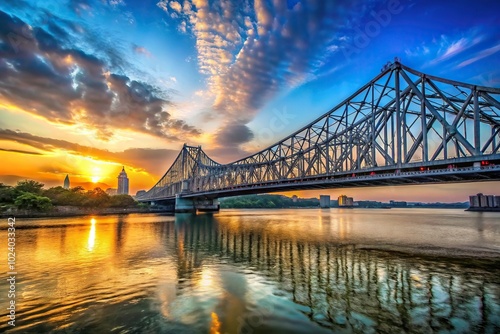 Historic Howrah bridge in Kolkata during sunset over blue sky photo